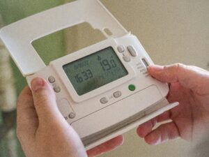 A man looking at a control for heating.