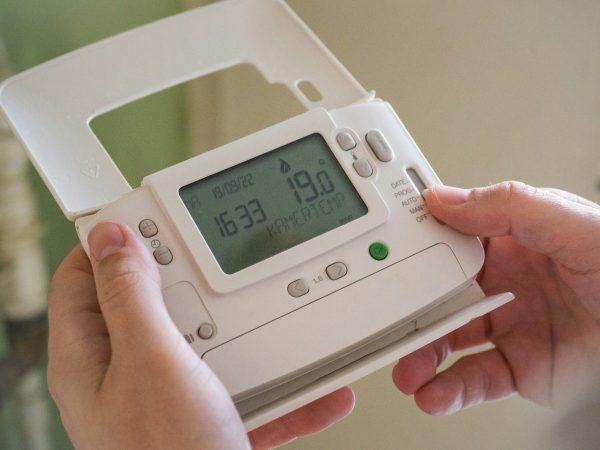 A man looking at a control for heating.